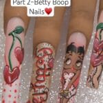 Full Betty Boop nail art set on long press-on tips — polka dots with 3D cherries, snakeskin with hand-lettered Betty Boop script, full-body Betty portrait nail, and 3D heart cherry accent