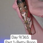 Hand-painted Betty Boop full-body character nail art on a single almond press-on tip — red lips, polka dot dress, freehand painted
