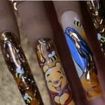 Winnie the Pooh freehand nail art on long press-on tips with gold chrome honeycomb texture and 3D sculpted honey drips