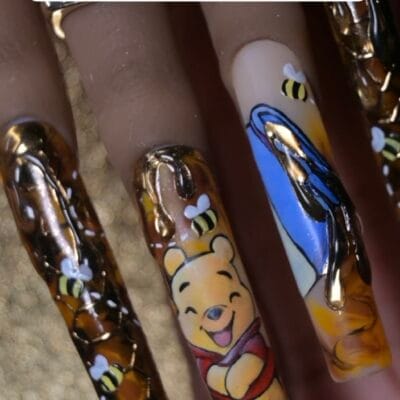 Winnie the Pooh freehand nail art on long press-on tips with gold chrome honeycomb texture and 3D sculpted honey drips