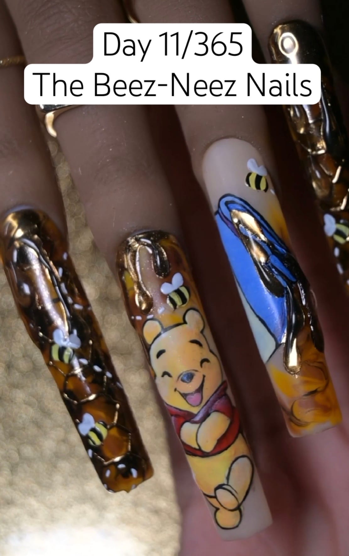 Winnie the Pooh freehand nail art on long press-on tips with gold chrome honeycomb texture and 3D sculpted honey drips